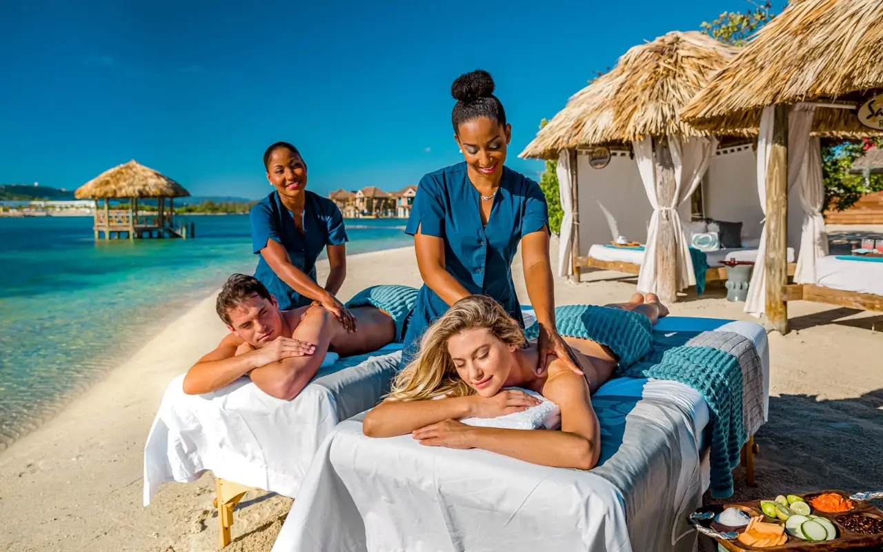 2-Black-women-giving-beach-massage-to-a-white-couple-in-Jamaica (1)
